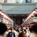 A bustling crowd in Nakamise Street, leading to Senso-ji Temple in Tokyo, Japan.