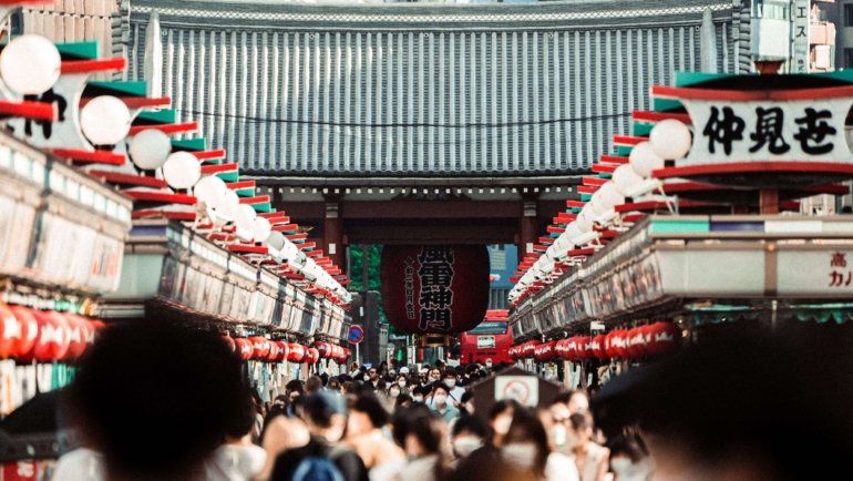 A bustling crowd in Nakamise Street, leading to Senso-ji Temple in Tokyo, Japan.